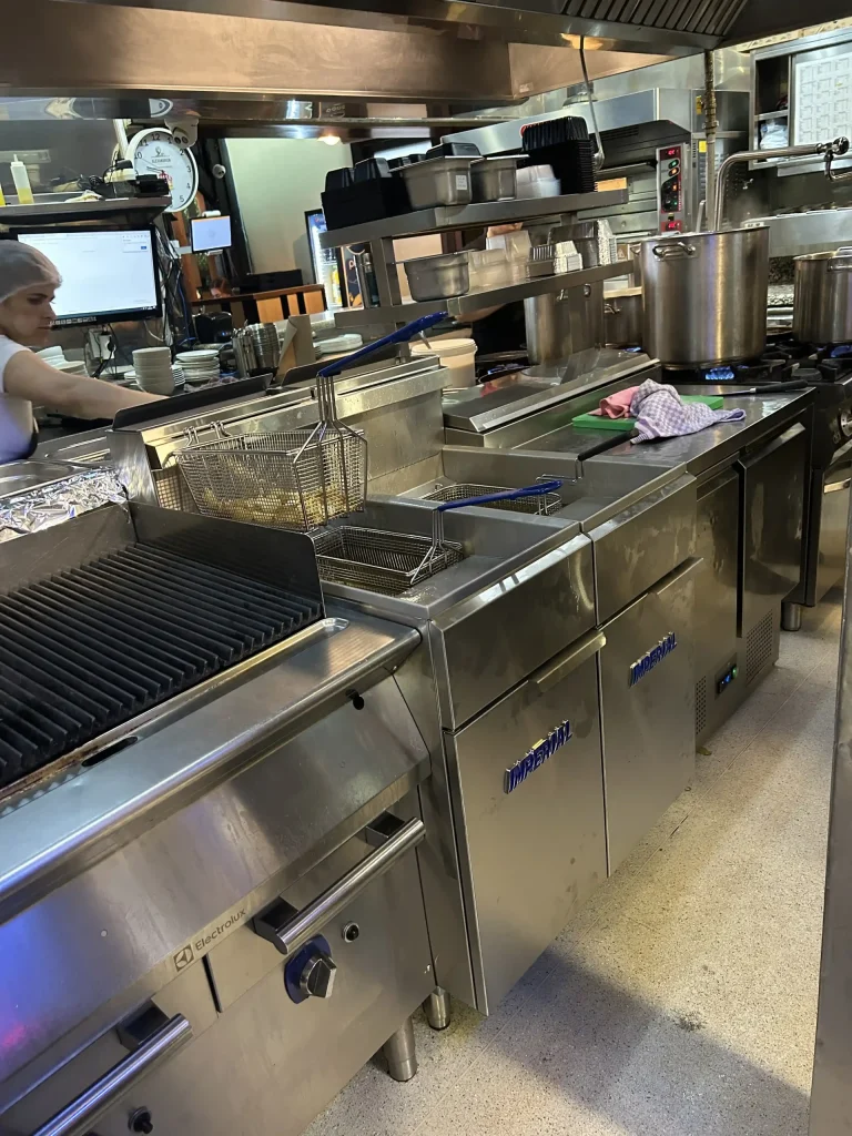 Linie de friteuze și grill într-o bucătărie profesională deservită de Polidom